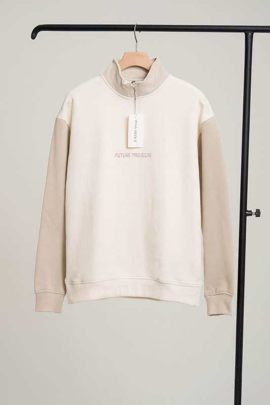 Beige sweatshirt with a tag on a hanger against a gray background
