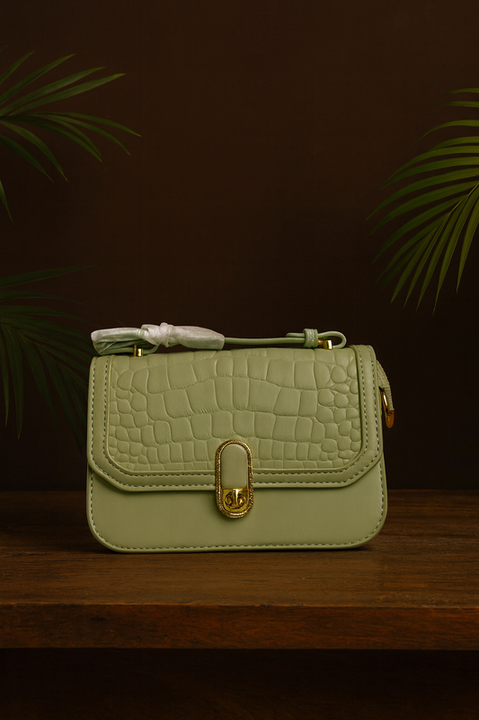Light green handbag with gold lock on a dark background