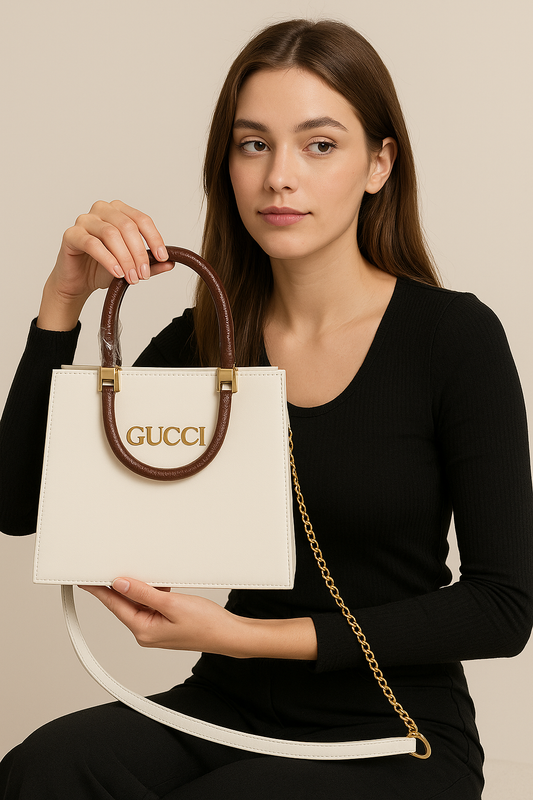 Woman holding a white Gucci handbag with a gold chain detail against a beige background