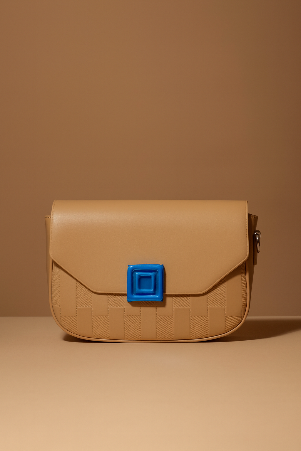 Beige handbag with a blue square clasp on a beige background