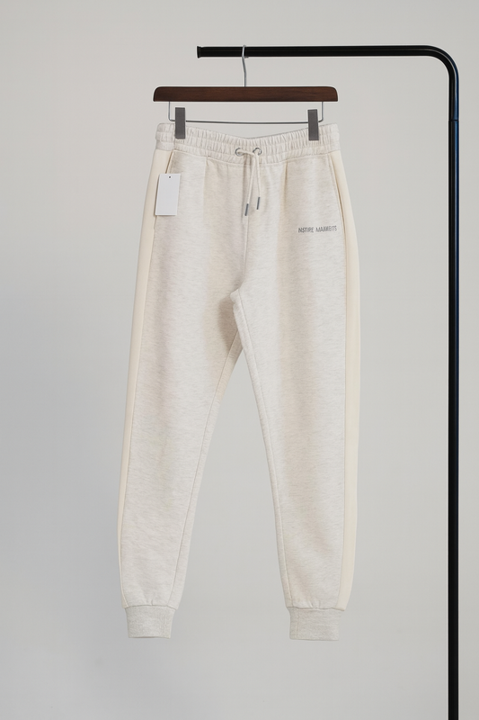 Beige sweatpants on a hanger against a plain background