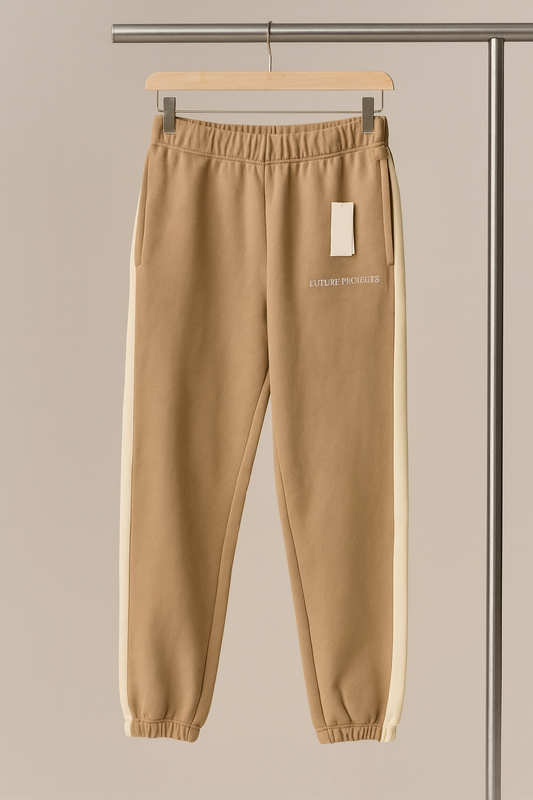 Beige sweatpants on a hanger against a neutral background