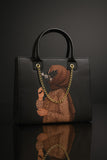 Black handbag with artistic design of a person wearing a hijab and gold chain on a dark background