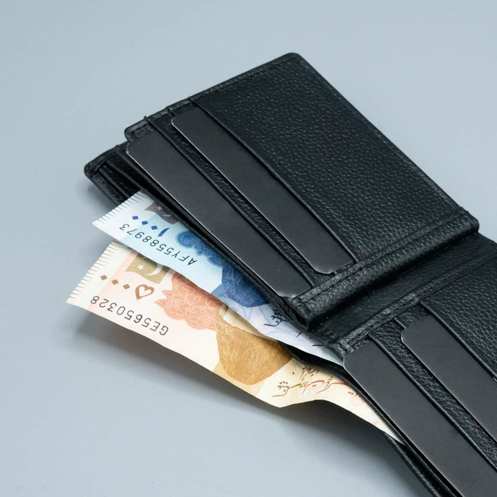 Black leather wallet with money and cards on a light gray background