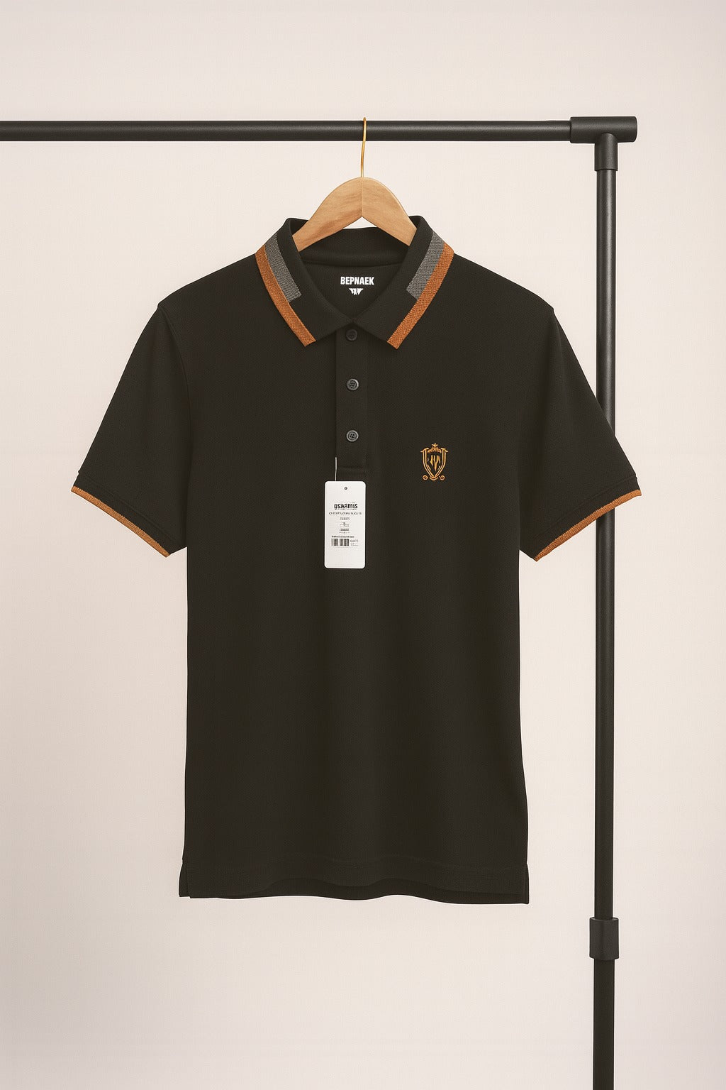 Black polo shirt with brown accents on a hanger against a beige background