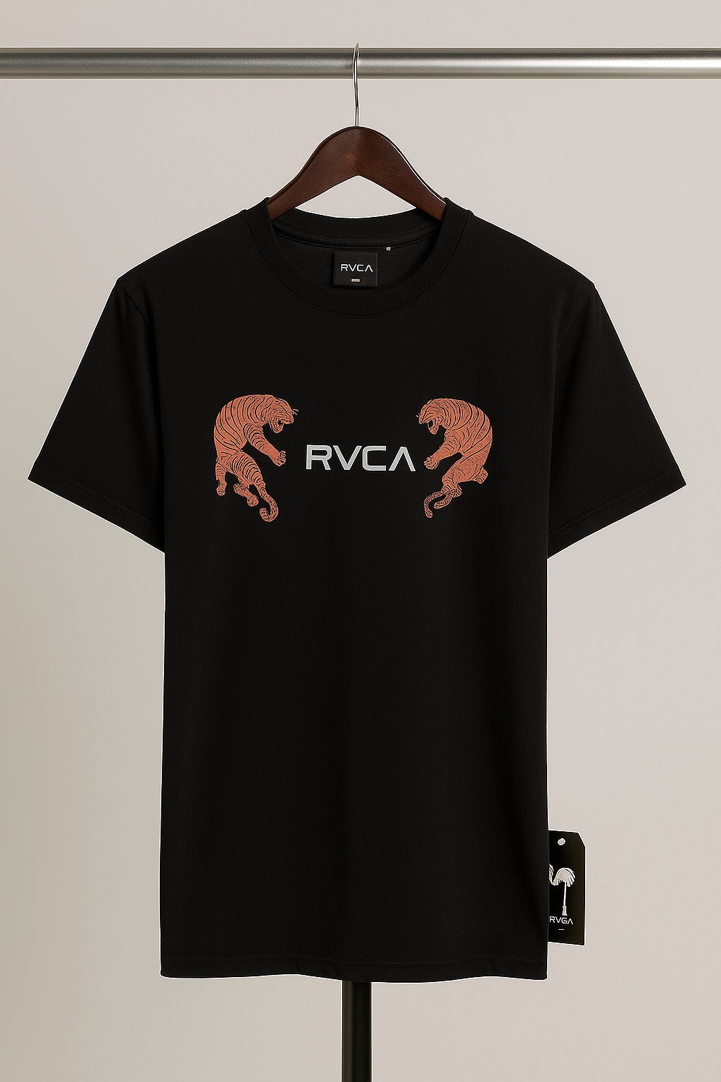 Black t-shirt with RVCA logo and panther graphics on a hanger against a neutral background
