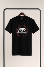 Black t-shirt with a logo on a hanger against a beige background