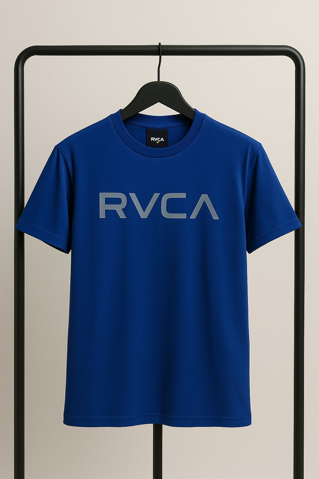 Blue t-shirt with 'RVCA' logo on a hanger against a beige background