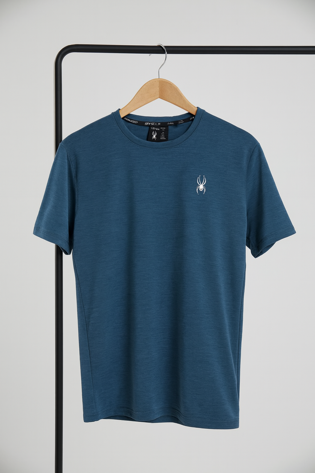 Blue t-shirt with a logo on a hanger against a white background