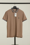 Brown Polo shirt with a tag on a hanger against a beige background