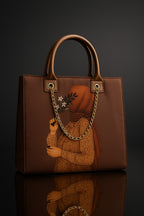 Brown handbag with artistic depiction of a person holding flowers on a dark background