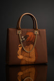 Brown handbag with artistic depiction of a person holding flowers on a dark background