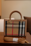 Brown handbag with plaid pattern on a wooden surface