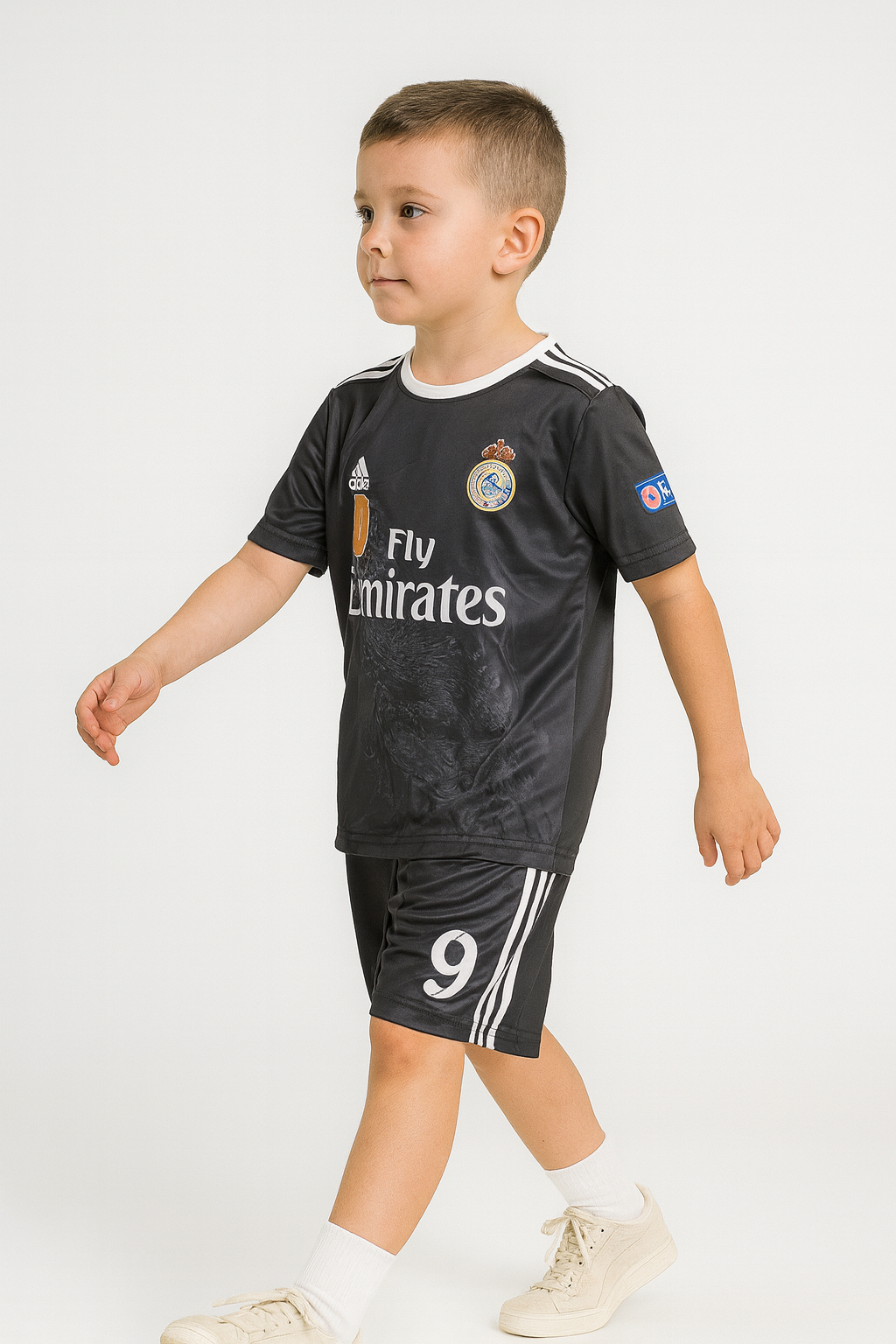 Child wearing a black sports outfit with visible branding on a white background