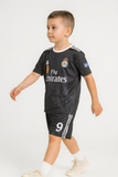 Child wearing a black sports outfit with visible branding on a white background