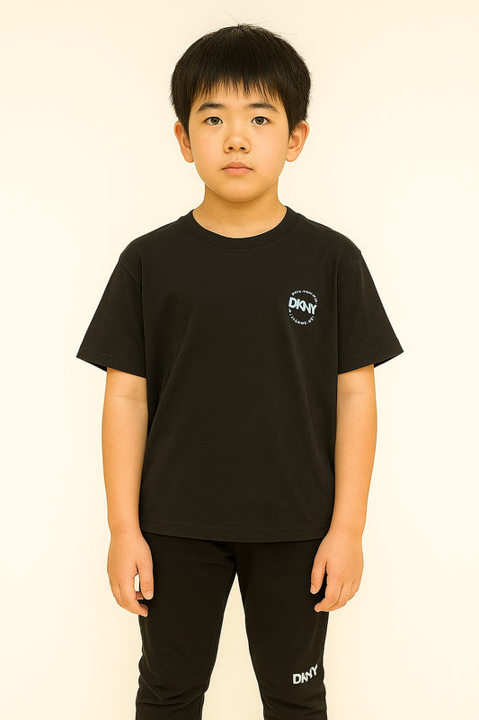 Child wearing a black t-shirt with a logo on a beige background