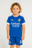 Child wearing a blue sports jersey with visible branding on a plain background