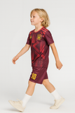 Child wearing a maroon sports outfit with yellow accents on a white background