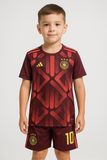 Child wearing a maroon sports jersey with red geometric patterns and yellow accents on a white background