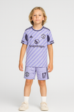 Child wearing a purple sports jersey with visible branding on a white background