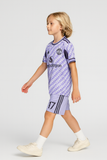 Child wearing a purple sports outfit with visible branding on a white background