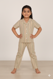 Child wearing a striped pajama set on a plain background