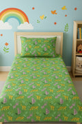 Children's room with green bedding featuring animal patterns, a rainbow, and colorful wall decals.
