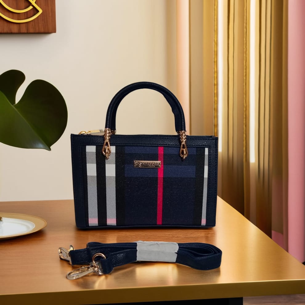 Designer handbag with striped pattern on a wooden surface with a plant in the background