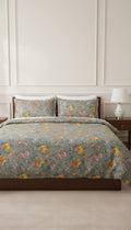 Floral bedding set on a bed in a bedroom with a lamp in the background.