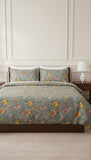 Floral bedding set on a bed in a bedroom with a lamp in the background.