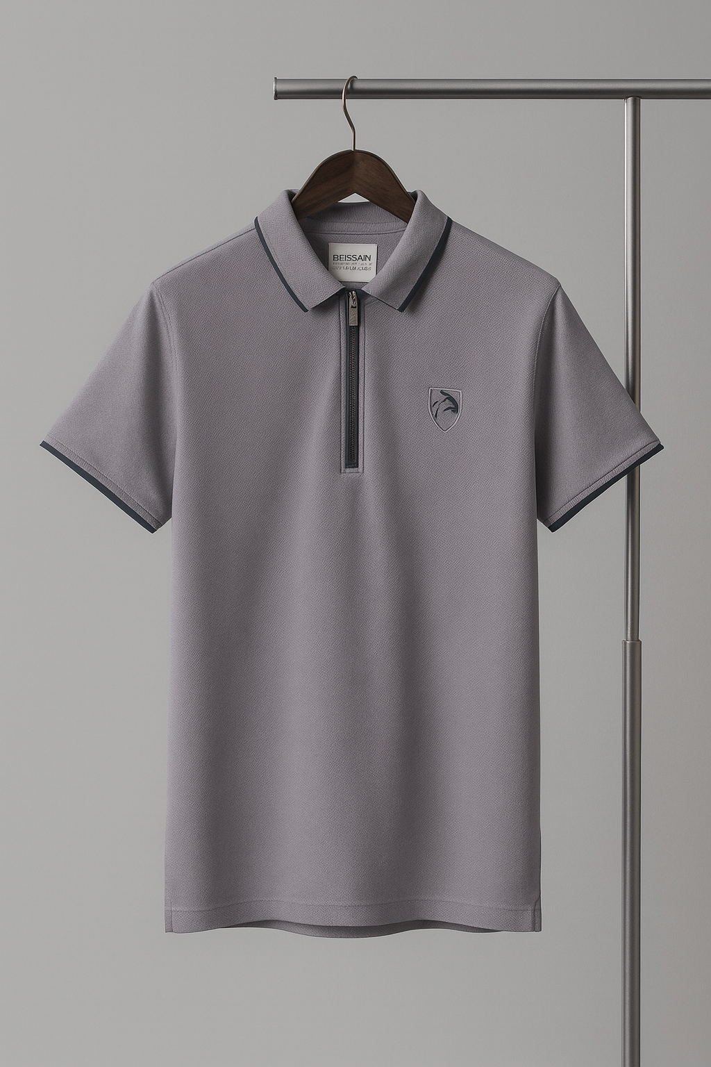 Gray polo shirt with a small logo on a hanger against a gray background