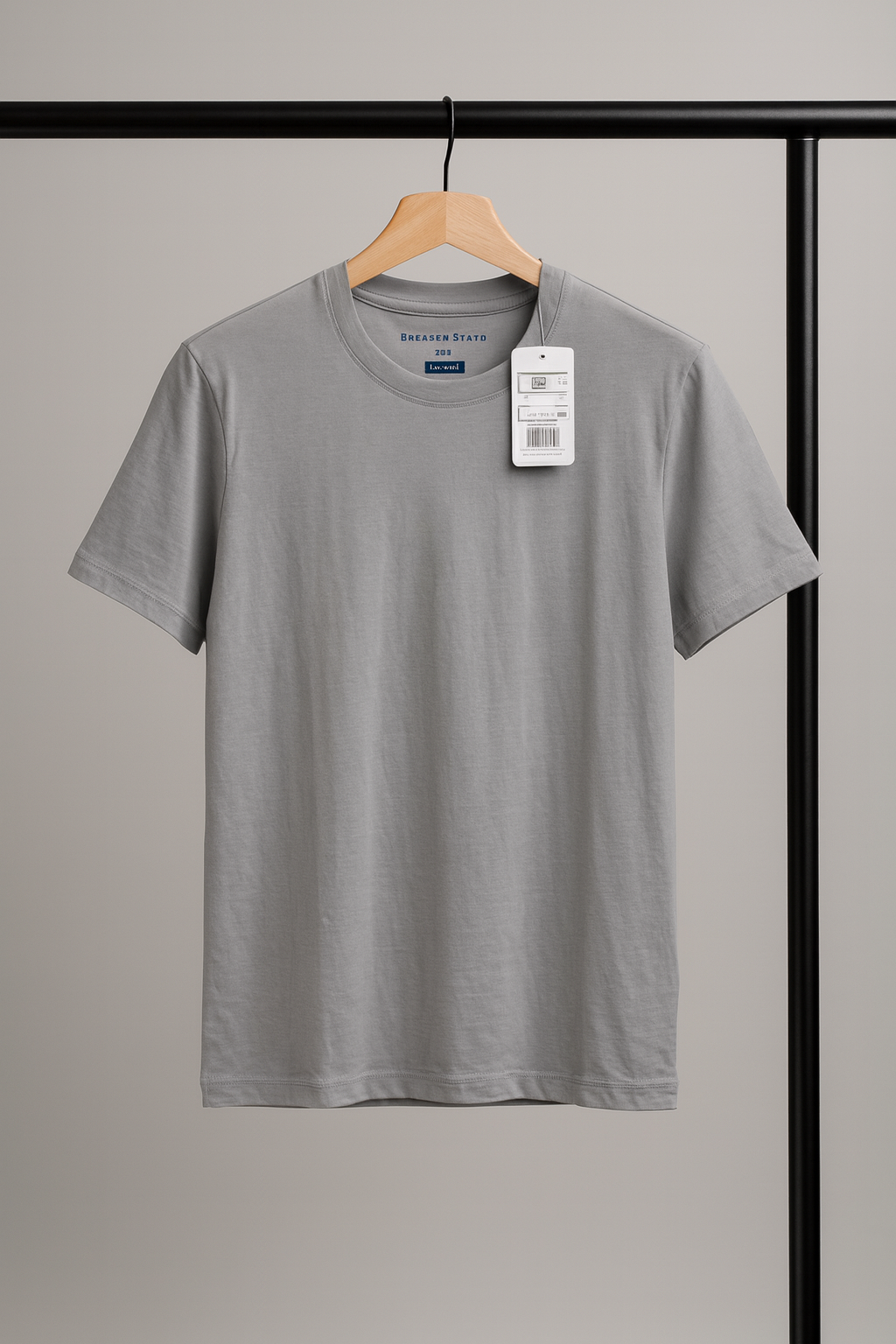 Gray t-shirt on a hanger with a tag against a neutral background