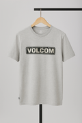 Gray t-shirt with Volcom logo on a hanger against a gray background