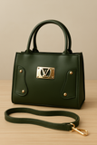 Green handbag with gold accents on a wooden surface