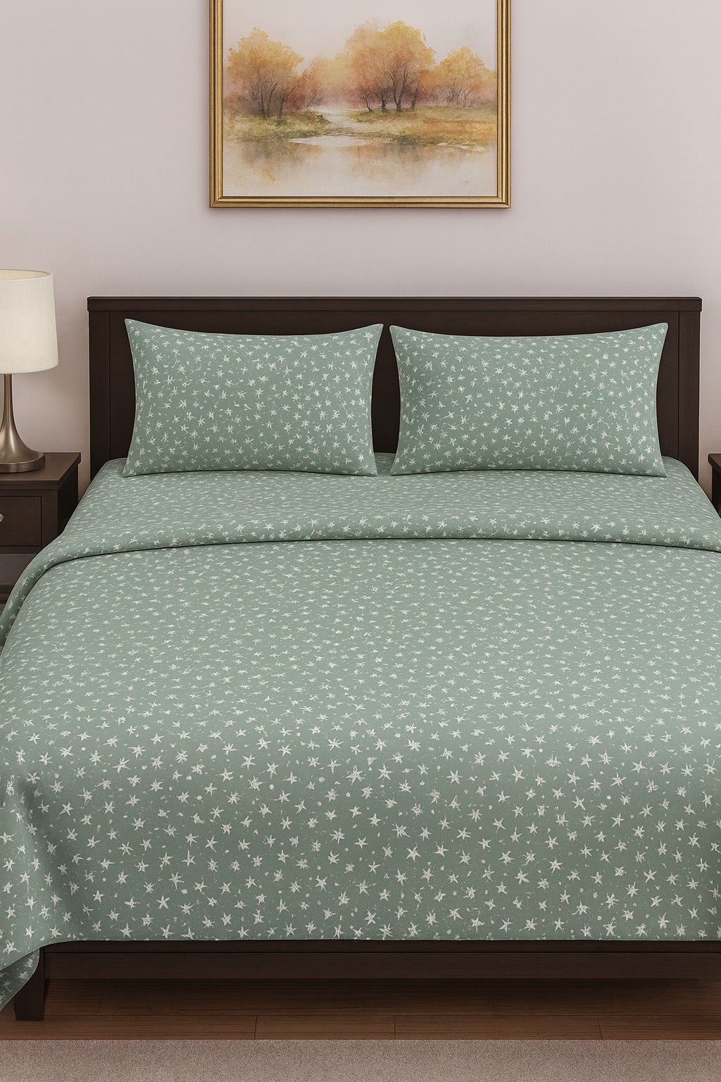 Green patterned bedding set on a bed with a framed picture on the wall.