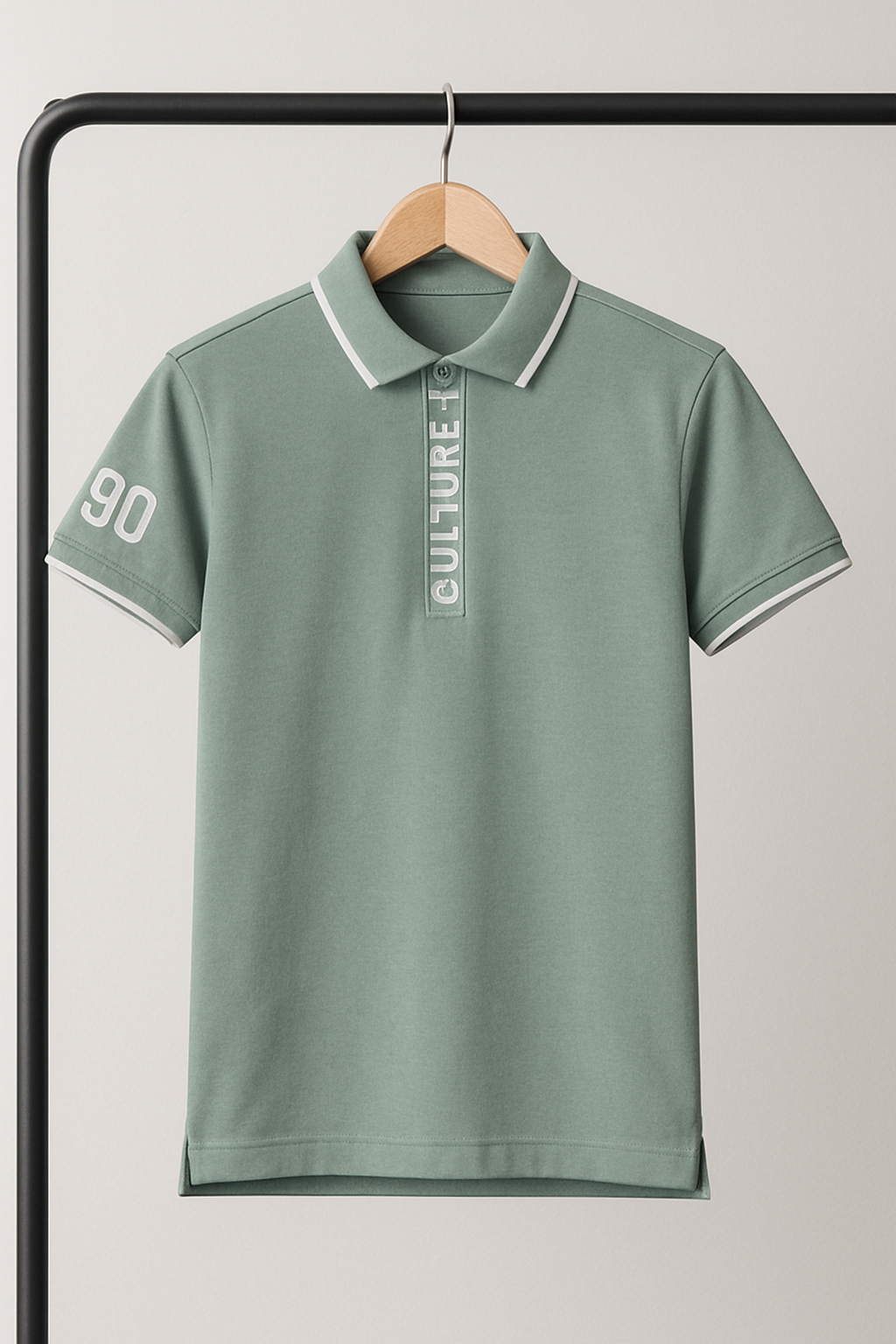 Green polo shirt with text and numbers on a hanger against a light gray background