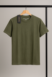 Green t-shirt on a hanger against a neutral background