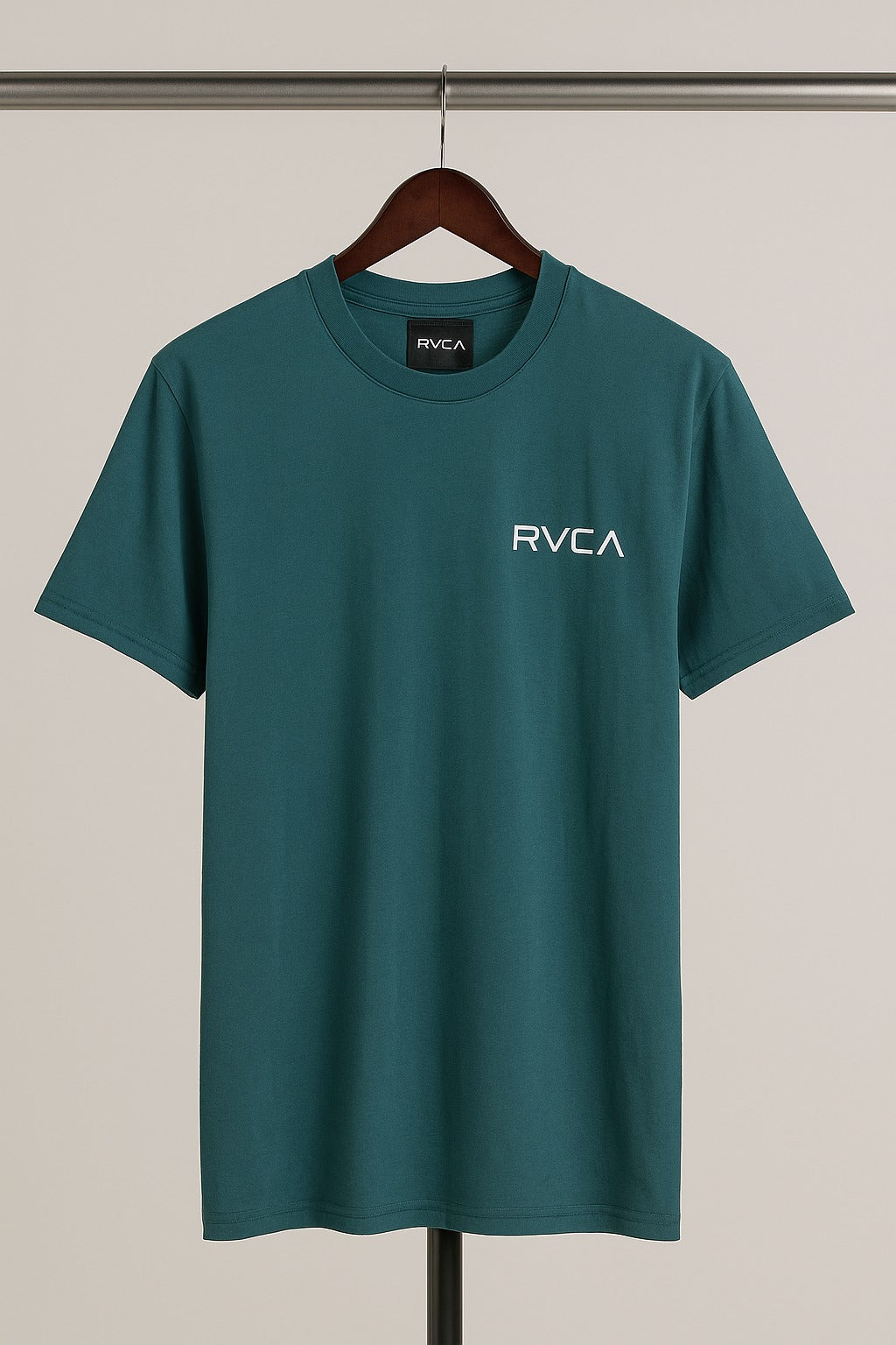 Green t-shirt with RVCA logo on a hanger against a neutral background