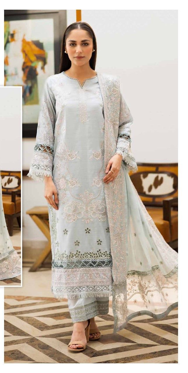 Woman wearing a light blue embroidered outfit with a matching shawl in an indoor setting.