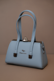 Light blue handbag with brown accents on a brown background