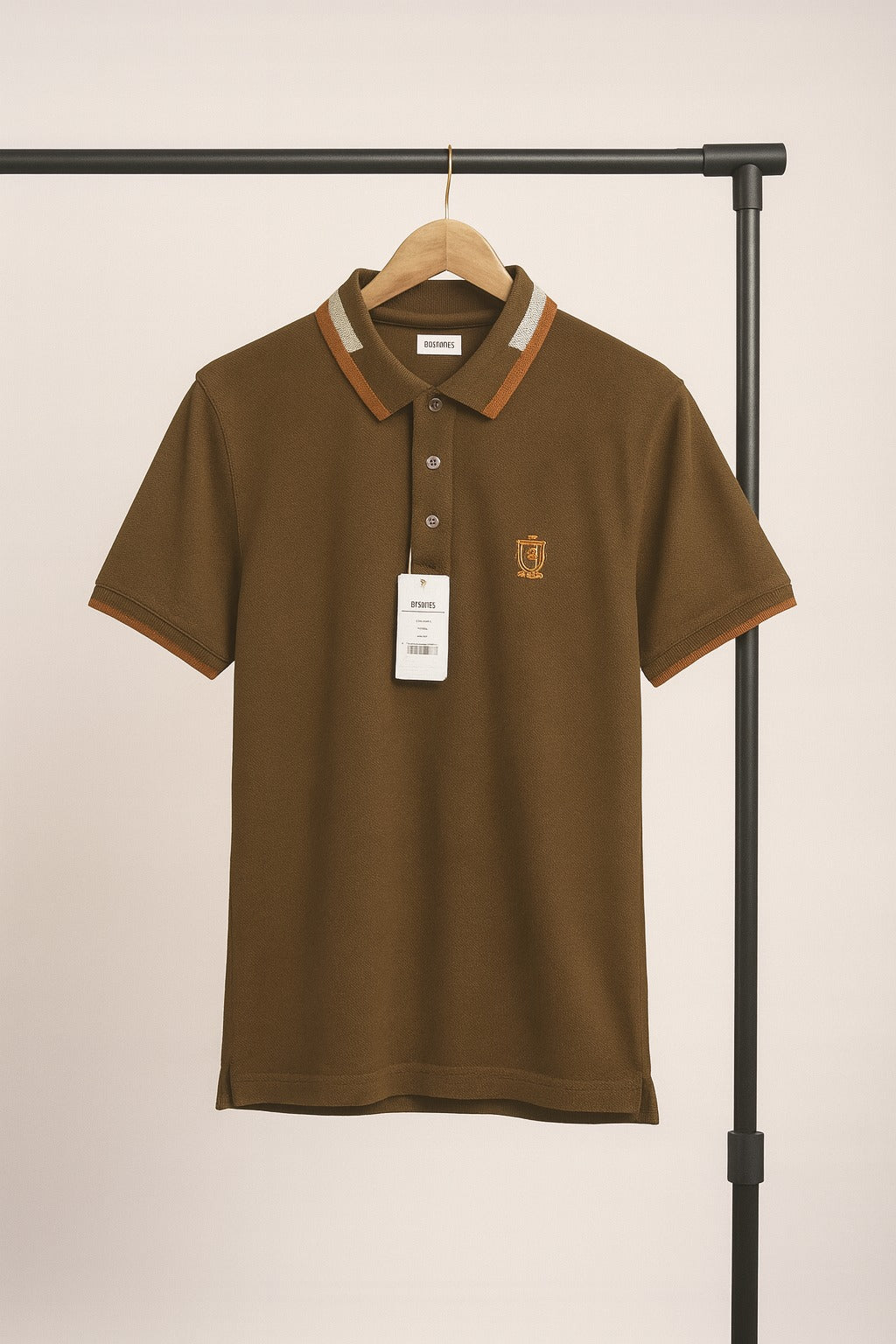 Mahndi polo shirt on a hanger against a beige background