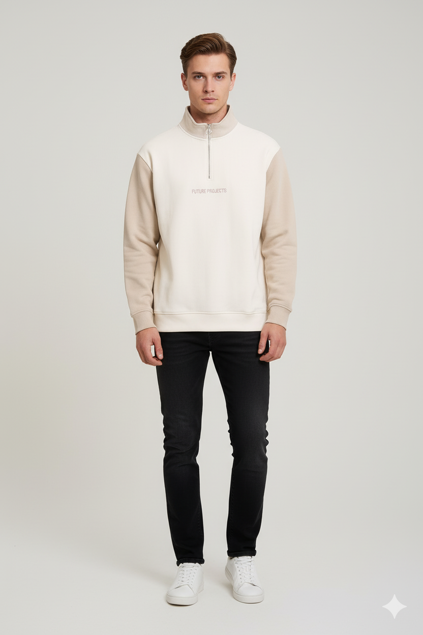 Man wearing a beige hoodie, black jeans, and white sneakers on a light gray background