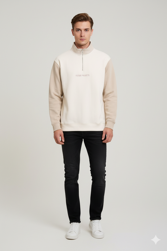 Man wearing a beige hoodie, black jeans, and white sneakers on a light gray background