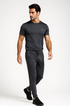 Man wearing a black Adidas t-shirt and trouser on a white background
