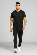 Man wearing a black Under Armour t-shirt and trouser on a gray background