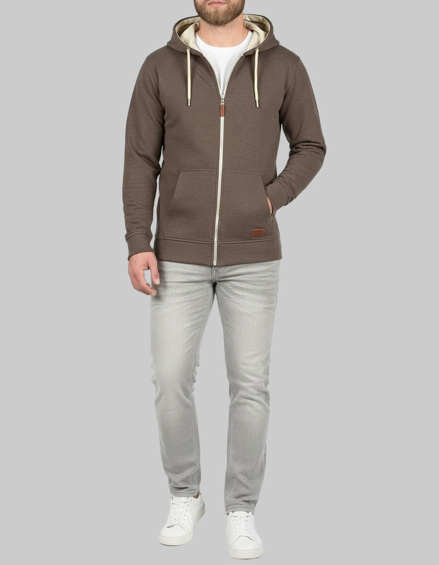 Man wearing a brown hoodie with a zipper on a gray background