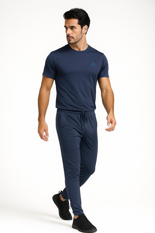 Man wearing a navy Adidas t-shirt and trouser on a white background
