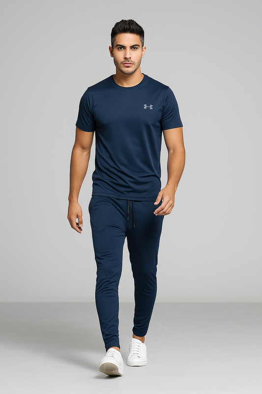 Man wearing a navy Under Armour t-shirt and trouser pants on a gray background