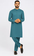 Man wearing a teal kurta with pants on a white background