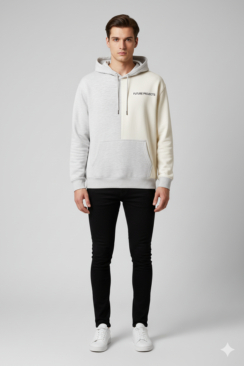 Man wearing a two-tone hoodie with black pants on a gray background